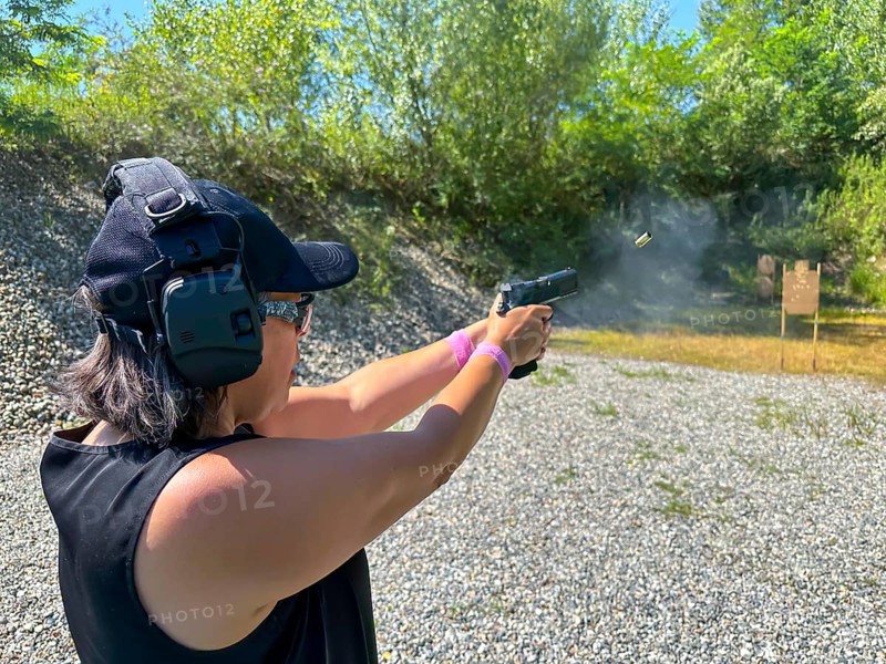 Woman Shooting in Motion on an Outdoor IPSC Shooting Range in a Sunny Summer Day in Switzerland