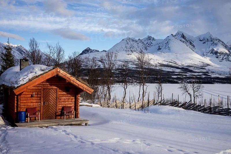 Wooden hut, snow mountains norway tromsö lake frozen over
