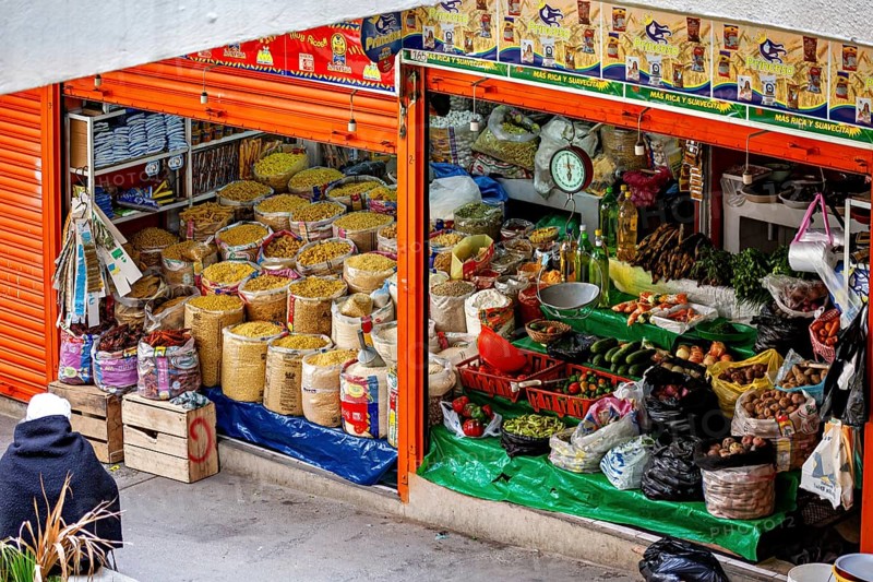 Lush market stall with different types of grain and traditional foods, small shops and restaurants in the market halls of La Paz in Bolivia