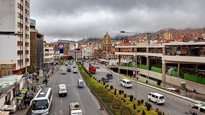 Urban scene with a wide street, traffic, a church and clouds over the mountains, The main streets in the city centre of La Paz in Bolivia