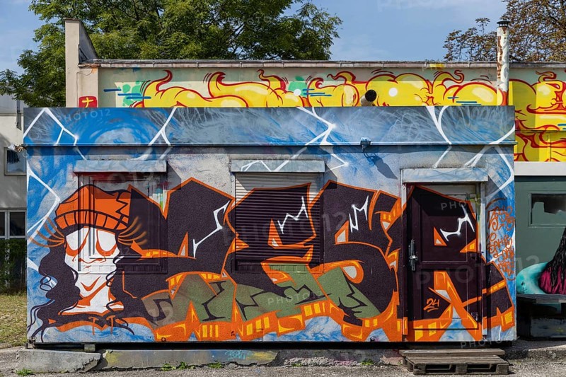Colourful graffiti wall with lively figures and letters in an urban environment, at the port of Linz Upper Austria Austria