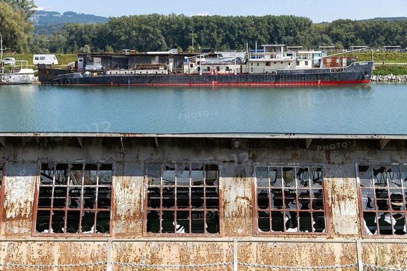 Industrial landscape with abandoned plant and ships in the background, at the harbour of Linz Upper Austria Austria