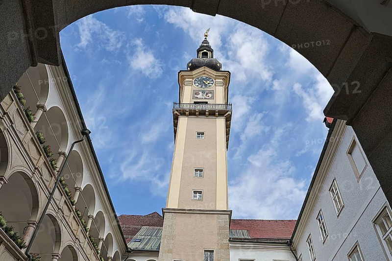 Historic clock tower above an inner courtyard with sky and surrounding arcades, Arkardenhof Landhaus Linz Upper Austria Austria