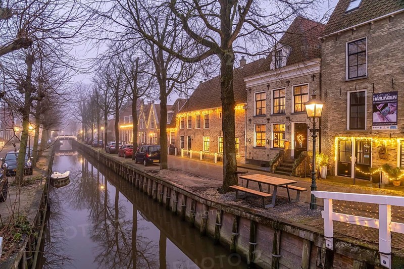 Typical canal in the foggy evening twilight, Harlingen, Friesland, Netherlands