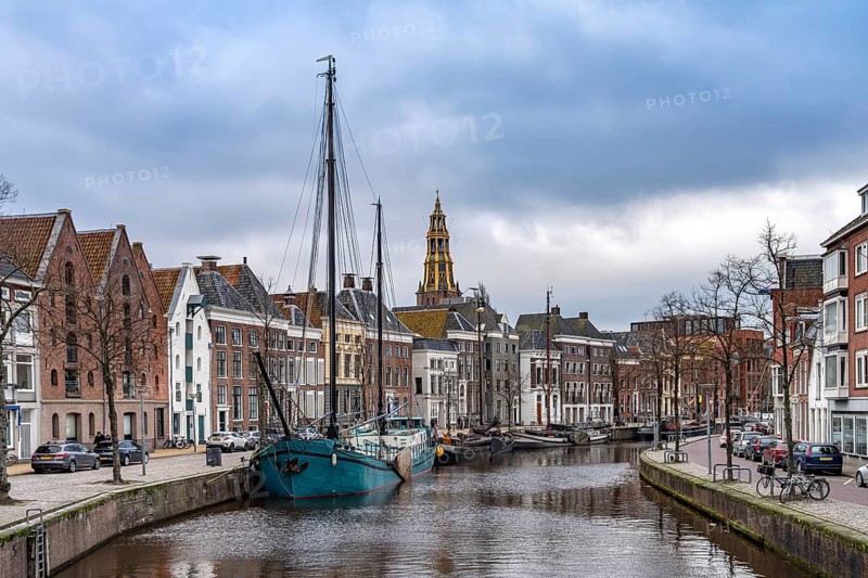 Typical canal with sailing boats and the tower of the Aa church in Groningen, Netherlands