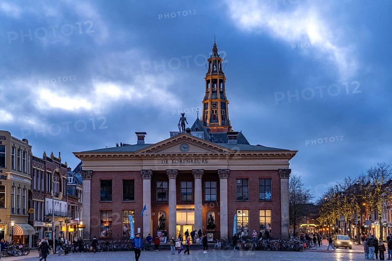 The Vismarkt fish market with the Korenbeurs former grain exchange and the steeple of the Aa church at dusk, Groningen, Netherlands