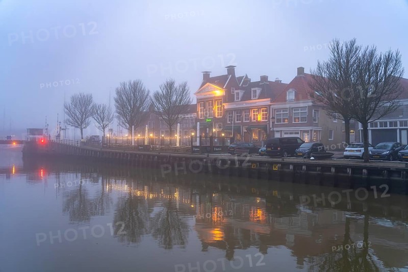 Typical canal in the foggy evening twilight, Harlingen, Friesland, Netherlands