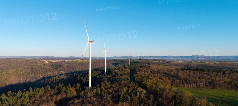 Wind turbines on a wooded hill under a clear blue sky, near Schorndorf im Remstal, Baden-Württemberg, Germany