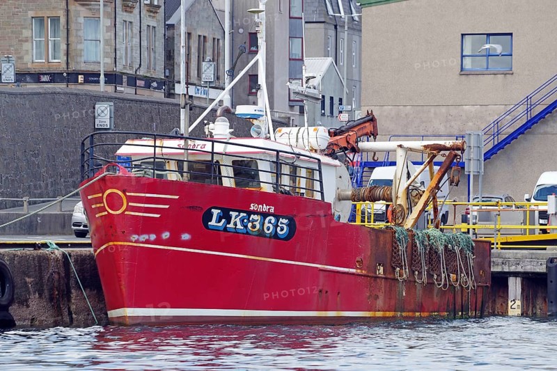 Red fishing boat in harbour against urban background with ropes on board, Lerwick, Shetland Islands, Scotland, Great Britain