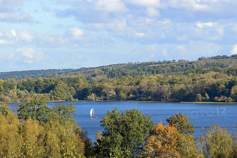 View of the Möhnesee with sailing boat, autumn atmosphere, blue cloudy sky, Möhnetalsperre, North Rhine-Westphalia, Germany