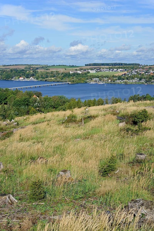 View over the Möhnesee, Körbecke village with the lake park and the lakeside promenade, blue cloudy sky, Möhnetalsperre, North Rhine-Westphalia, Germany