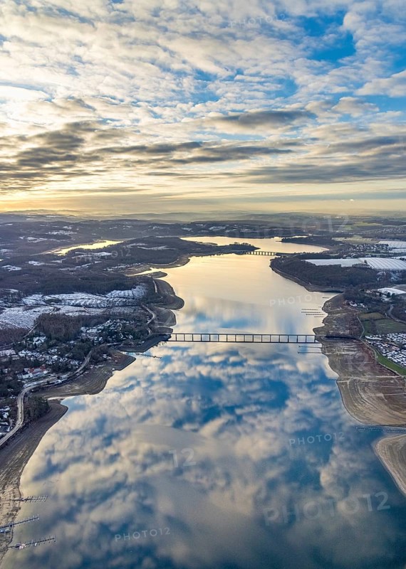 Aerial view of Lake Möhnesee in winter with snow and reflections of clouds on the water surface at low tide in Körbecke in Möhnesee in Sauerland in North Rhine-Westphalia, Germany, Sauerland, Europe, aerial view, birds-eyes view, aerial photography, aerial photography, overview, bird's eye view