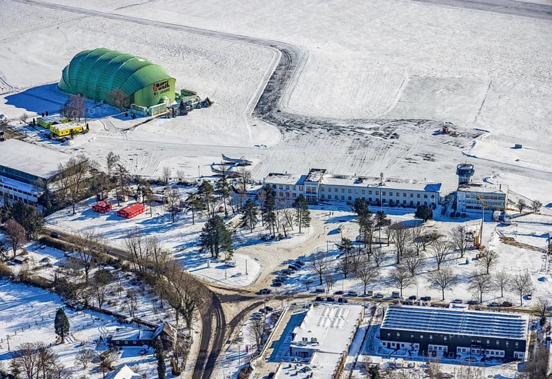 Aerial view, airship hangar, reception building, Essen / Mülheim airport in winter, Holthausen - south-east, Mülheim an der Ruhr, Ruhr area, North Rhine-Westphalia, Germany, DE, Europe, flight mission, airport, aircraft noise, airfield, control tower, runway, aerial photograph, aerial photography, aerial photography, snow, runway, overview, bird's-eye view, winter, birds-eyes view, overview