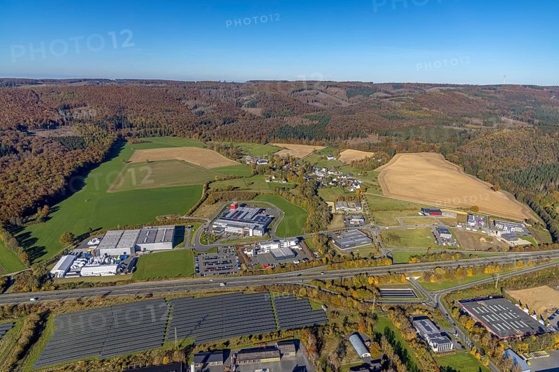 Aerial view, commercial area Enste with solar park at the motorway A46 in the district Enste in Meschede, Sauerland, North Rhine-Westphalia, Germany, DE, Europe, commercial enterprises, commercial area, commercial park, commercial location, commercial use, industrial area, industrial building, industrial location, aerial view, aerial photography, aerial photography, Meschede, photovoltaic, photovoltaic plant, solar, solar plant, solar roof, solar energy, solar park, overview, bird's-eye view, birds-eyes view, overview