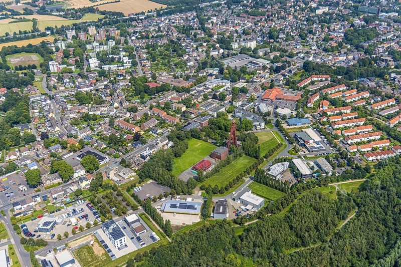 Aerial view, Start-up centre and Technopark Kamen on the former site of the Monopol Schacht Grillo colliery with winding tower Kamen, garden settlement Gertrud-Bäumer-Straße and Helene-Lange-Straße with red roofs in Kamen, Ruhr area, North Rhine-Westphalia, Germany, mining, DE, Europe, winding tower, commercial enterprises, commercial area, commercial location, commercial use, industrial area, industrial location, Kamen, aerial view, aerial photography, aerial photography, sight, coal mine, technology park, tower, overview, bird's-eye view, former mine, overview