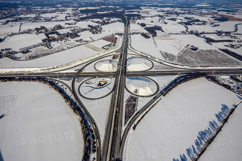 Aerial view, Kamen junction in winter, A1 and A2, helicopter sculpture Yellow Angel, Kamen, Ruhr area, North Rhine-Westphalia, Germany, motorway A1, motorway A2, motorway junction, DE, Europe, cloverleaf shape, aerial view, aerial photography, aerial photography, snow, sculpture, overview, bird's eye view, winter, birds-eyes view, overview