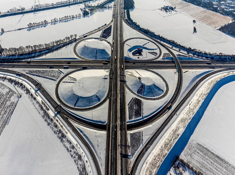 Aerial view, Kamen junction in winter, A1 and A2, helicopter sculpture Yellow Angel, Kamen, Ruhr area, North Rhine-Westphalia, Germany, motorway A1, motorway A2, motorway junction, DE, Europe, cloverleaf shape, aerial view, aerial photography, aerial photography, snow, sculpture, overview, bird's eye view, winter, birds-eyes view, overview