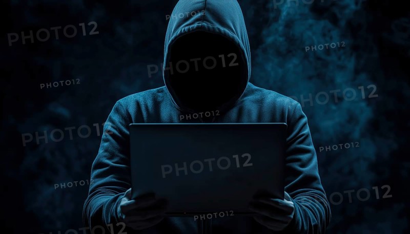 Dark Face Of Cyber Crime: Anonymous Hooded Hacker With Laptop Engaged In Internet Malware And System Break-Ins, AI generated