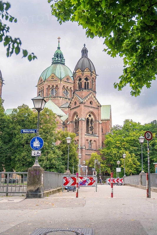 Impressive church with twin towers surrounded by trees on a cloudy day, Munich, Germany
