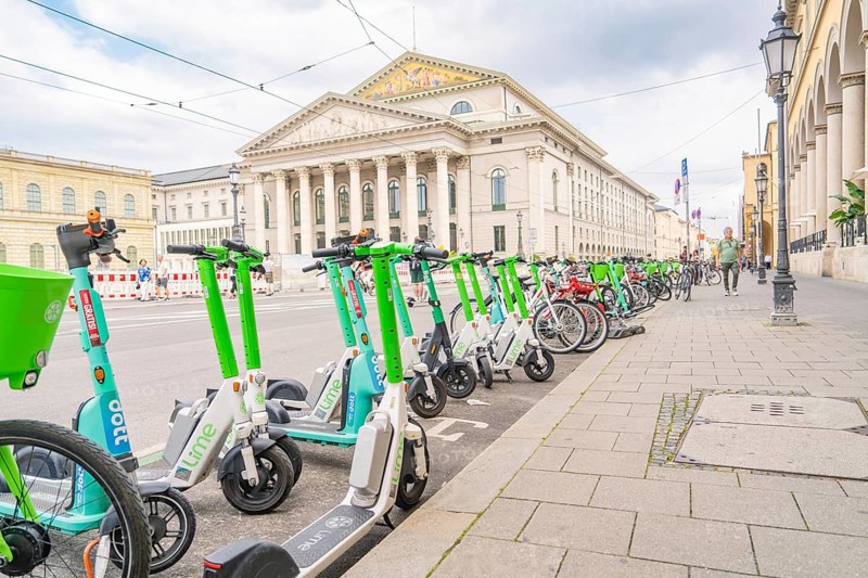 E-scooters and bicycles in front of a majestic building in the city of Munich, Munich, Germany