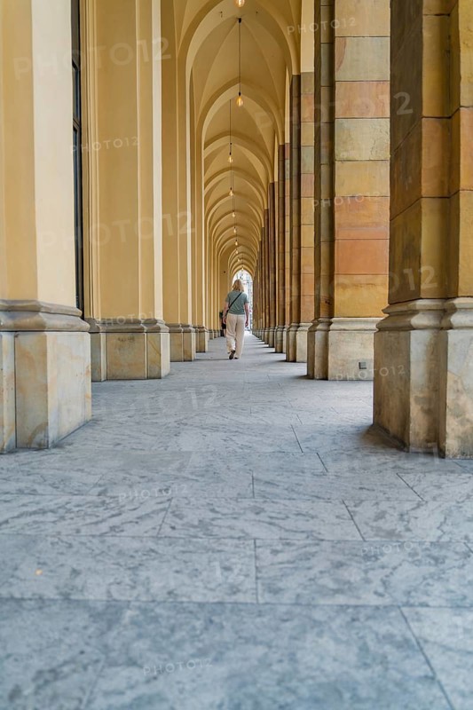 Long corridor with arches and columns, stone floor in a quiet atmosphere, Munich, Germany