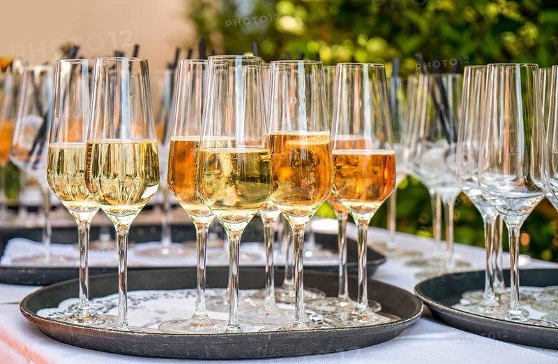 Outdoor garden scenery showing some half filled sparkling wine glasses on a tray