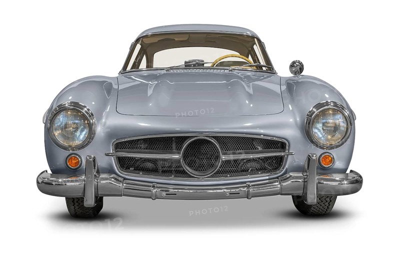 Frontal shot of a silver colored historic vehicle coupe in white back with shadow