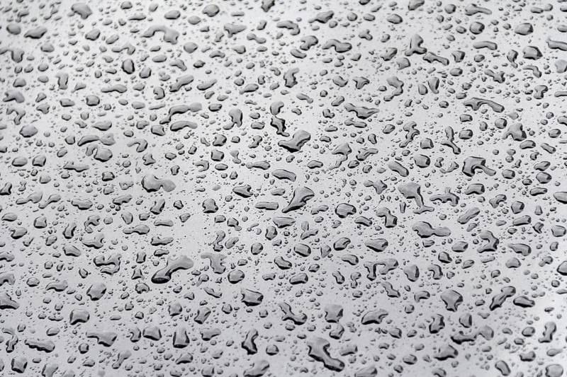 Abstract natural background showing a closeup of water beads on glossy repellent ground