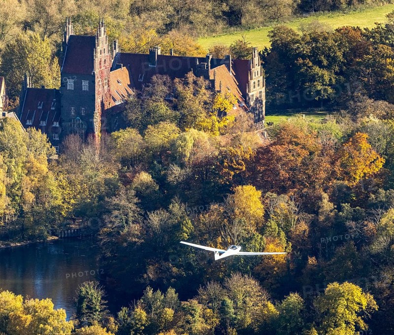 Aerial photo, motor glider at Heessen Castle in the autumnal forest in the Heessen district of Hamm, Ruhr area, North Rhine-Westphalia, Germany, education, educational institution, castle, DE, Europe, aircraft, Hamm, autumn colours, educational institute, aerial photo, aerial photography, aerial photography, motor glider, castle, castle complex, school, overview, bird's-eye view, overview