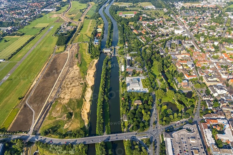 Aerial view, Hamm-Lippewiesen airfield, construction site for protective dam at Jupp-Eickhoff-Weg, Lippe beach, Lippe floodplain, Hamm lock, Lippe river, Datteln-Hamm canal, Hammonense grammar school, new water sports centre, Heessen, Hamm, Ruhr area, North Rhine-Westphalia, Germany, construction work, construction area, construction site, construction measure, construction project, construction site, education, educational institution, DE, Europe, flight emission, airport, aircraft noise, airfield, grammar school, sewage treatment plant Hamm Lippeverband, runway, educational institute, aerial photograph, aerial photography, aerial photography, North Rhine-Westphalia, school, runway, overview, bird's-eye view, overview