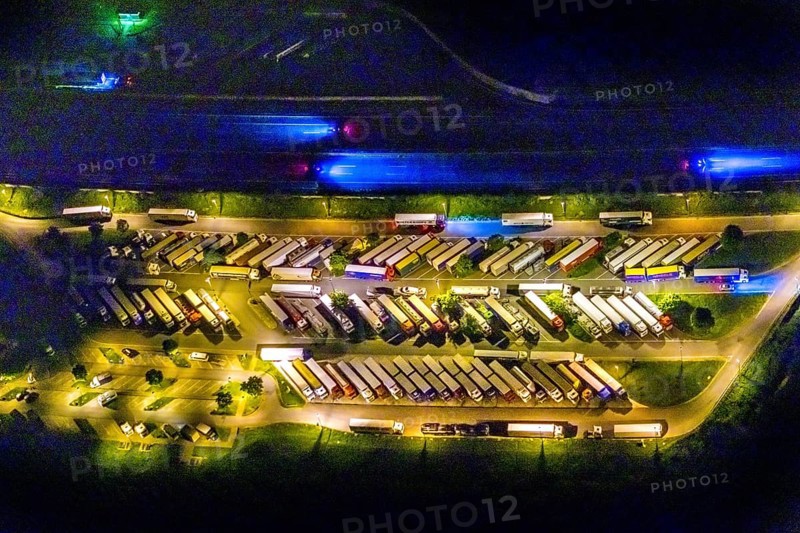 Aerial photo, motorway service area Resser Mark, Resse, Gelsenkirchen, Ruhr area, North Rhine-Westphalia, Germany, motorway A2, DE, twilight photography, Europe, shapes and colours, truck parking, tracers, light pollution, aerial photography, aerial photography, night, night photography, night flight, parking, road traffic, overview, bird's eye view, illuminated road traffic, birds-eyes view, nightflight, overview