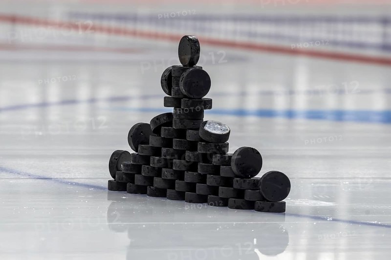 Ice hockey symbol image: Close-up of pucks stacked on the ice for the warm-up game