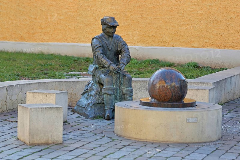 Monument to founder David Strickermann, town history on the development of the textile industry, seated male figure with tub and ball of wool, symbols, wool, ball, bronze sculpture, modern art, rotating granite ball, stone ball, fountain, Strickermannbrunnen, Schulplatz, Apolda, Thuringia, Germany