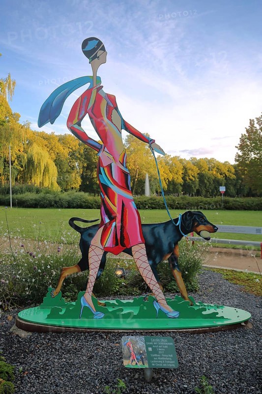 Sculpture Lady with Doberman by Carolin Okon 2017, modern art, colourful elegant female figure walking a dog, walk with dog, dog figure, walking, sports park, Apolda, Thuringia, Germany