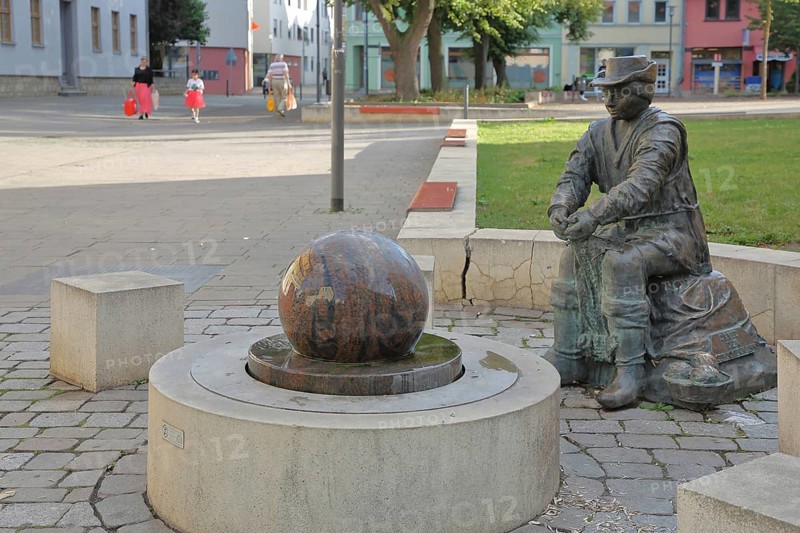 Monument to founder David Strickermann, town history on the development of the textile industry, seated male figure with tub and ball of wool, symbols, wool, ball, bronze sculpture, modern art, rotating granite ball, stone ball, fountain, Strickermannbrunnen, Schulplatz, Apolda, Thuringia, Germany