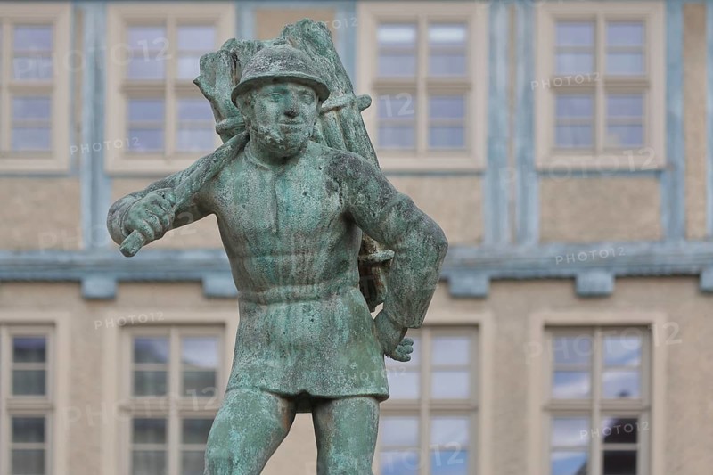 Wood carrier by Bernhard Frydag, 1914, male figure carrying basket with wood on his back, symbol for forestry, logging, lumberjack, wood, fountain, wood carrier fountain, wood market, Aschersleben, Harz, Saxony-Anhalt, Germany
