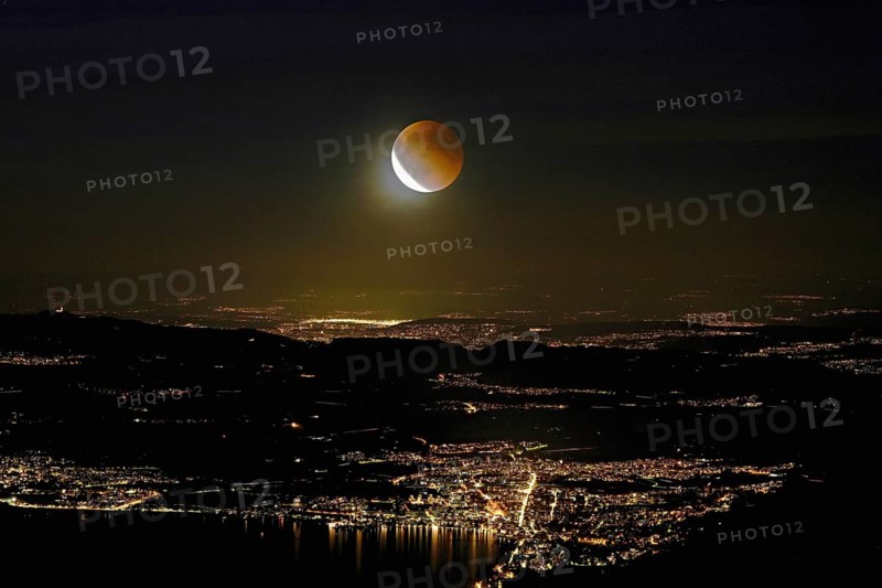 Blood moon, total lunar eclipse over the illuminated city and Lake Zug, Zug, Canton Zug, Switzerland