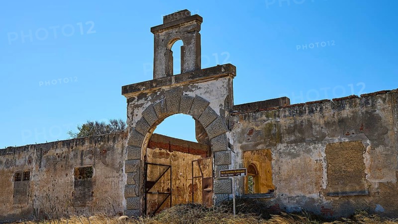Dilapidated archway of an old factory, surrounded by crumbling walls under a clear sky, Old silk factory, German Wehrmacht military prison, concentration camp, Lost Place, Kattavia, Rhodes, Dodecanese, Greek Islands, Greece