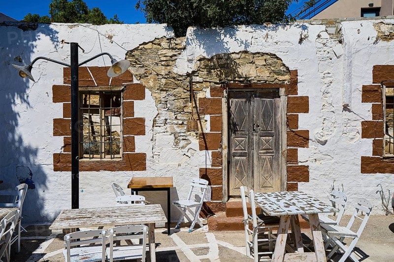 Taverna, Rustic wall with wooden doors, lights and weatherboarded brickwork, Kattavia village, southern tip of Rhodes, Rhodes, Dodecanese, Greek Islands, Greece
