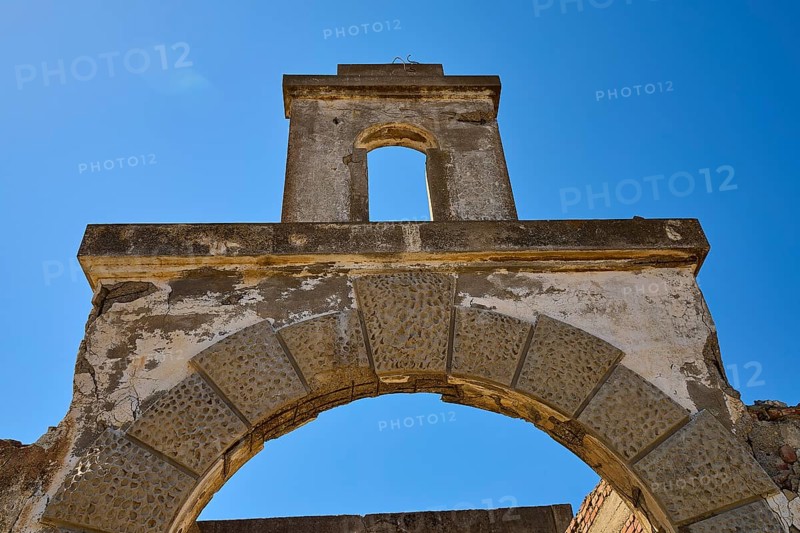 Abandoned stone archway under a clear blue sky, showing signs of weathering, Old Silk Factory, German Wehrmacht military prison, concentration camp, Lost Place, Kattavia, Rhodes, Dodecanese, Greek Islands, Greece