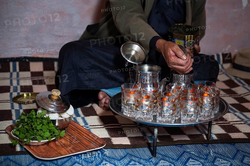 Moroccan man pouring traditional green tea into the kettle
