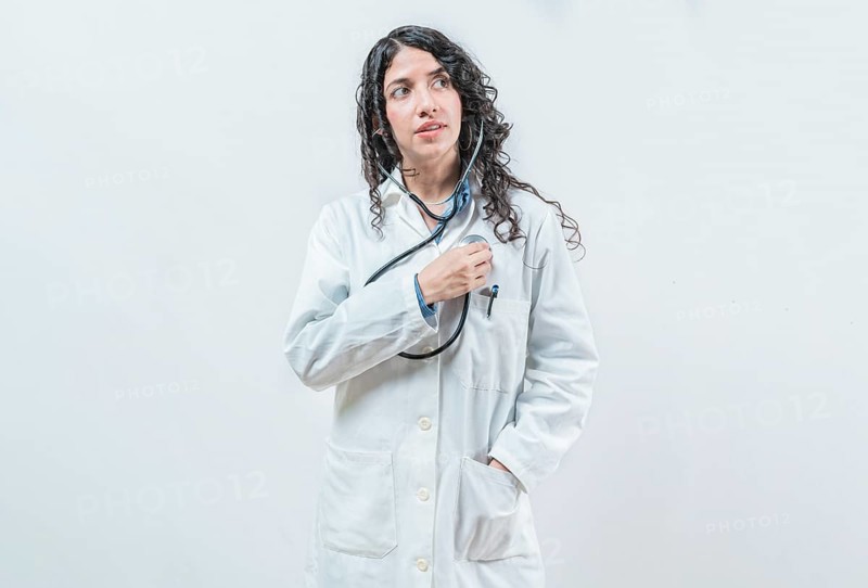 Doctor listening to her heart with stethoscope, isolated. Female doctor with stethoscope on her chest listening to her heart