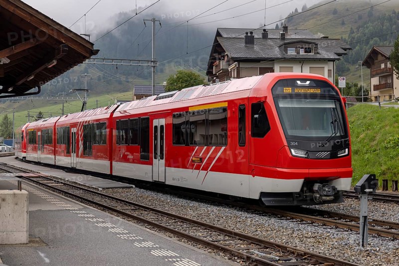 Metre-gauge electric low-floor multiple-unit trains of the Matterhorn-Gotthard Railway (MGB) ORION (Optimaler Regionalzug Im Oeffentlichen Nahverkehr) from Stadler, Sedrun station, Surselva, Grisons, Switzerland