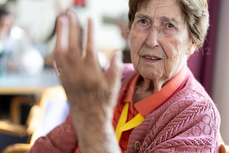 Over 90-year-old senior citizen with dementia talks and gesticulates with her wrinkled hands in a retirement home, Cologne, North Rhine-Westphalia, Germany