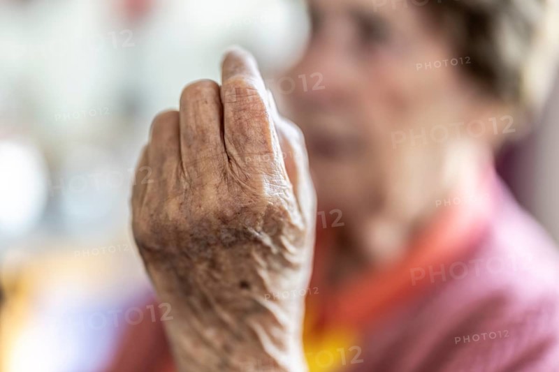 Over 90-year-old senior citizen with dementia talks and gesticulates with her wrinkled hands in a retirement home, Cologne, North Rhine-Westphalia, Germany