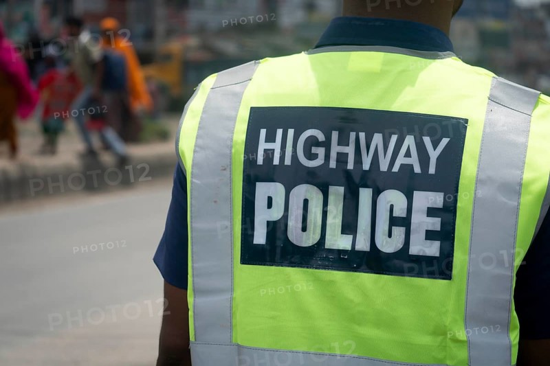 Highway police officer on duty viewed from the back with a reflective vest, Dhaka, Bangladesh