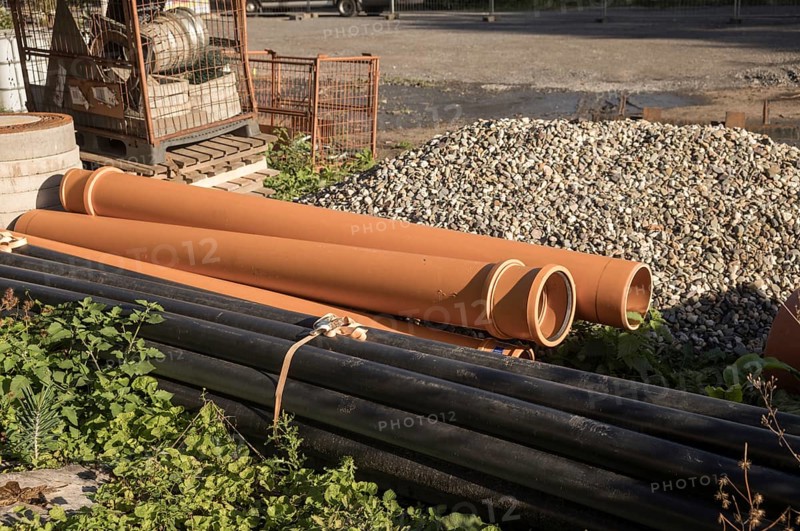 Borken, NRW, Germany, Orange and black plastic pipes are lying on a construction site, waiting to be installed
