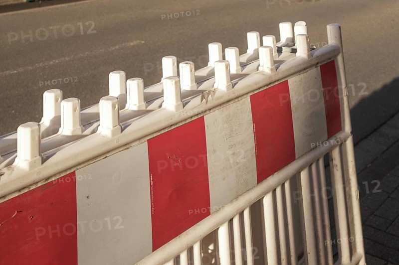 Borken, NRW, Germany, Red and white striped traffic barrier standing on a city street, ensuring safety and regulating traffic flow