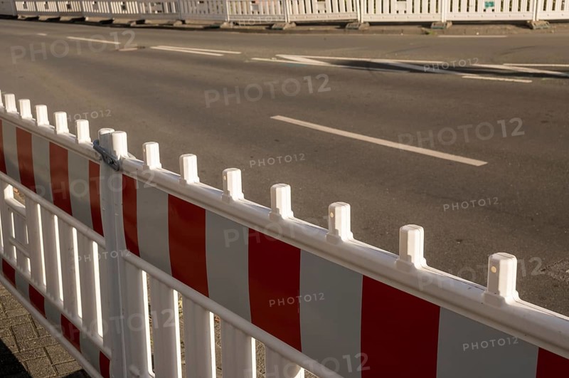 Borken, NRW, Germany, Red and white striped plastic construction barrier closing an empty asphalt street during roadworks