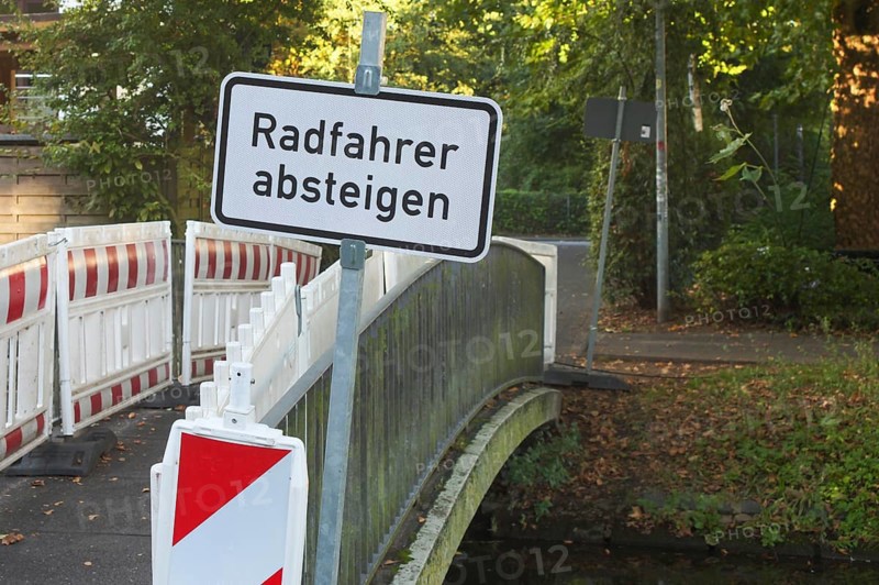 Borken, NRW, Germany, Cyclists dismount sign and construction barriers blocking access to a small bridge over a canal in germany